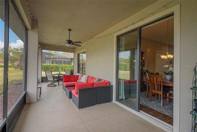 sunroom featuring a wealth of natural light and ceiling fan with notable chandelier