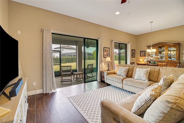 living room featuring dark hardwood / wood-style floors and ceiling fan with notable chandelier