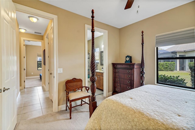 bedroom featuring ensuite bath, ceiling fan, tile floors, and multiple windows