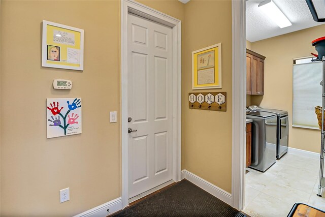 laundry area with cabinets, light tile floors, and separate washer and dryer