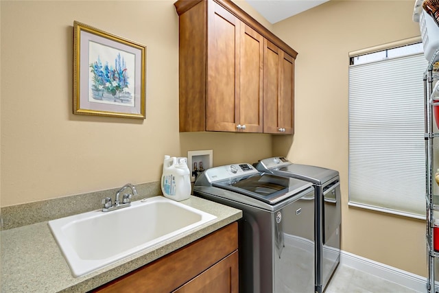 laundry room with cabinets, washing machine and dryer, hookup for a washing machine, sink, and light tile floors