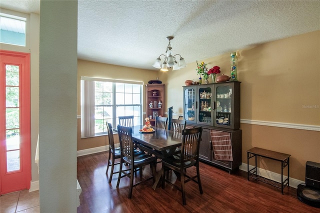 dining room featuring hardwood / wood-style flooring, a chandelier, and a textured ceiling