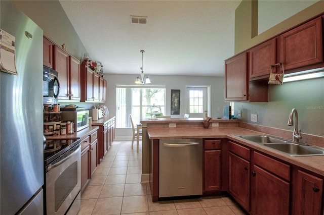 kitchen with light tile patterned floors, an inviting chandelier, stainless steel appliances, sink, and kitchen peninsula