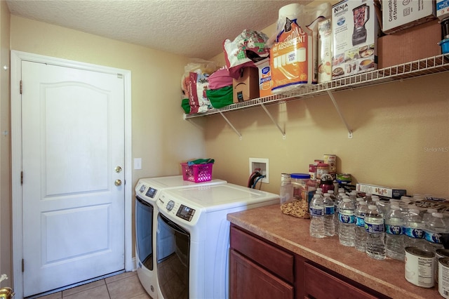 laundry area featuring light tile patterned floors, washer and clothes dryer, and a textured ceiling