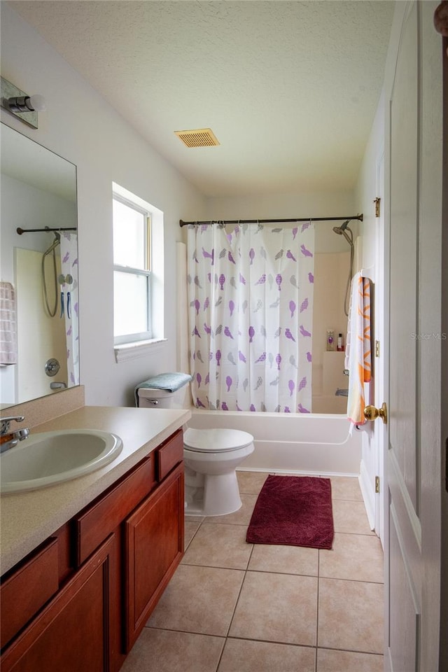 full bathroom with tile patterned floors, toilet, shower / tub combo with curtain, vanity, and a textured ceiling