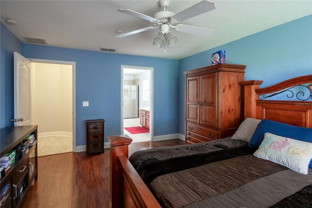 bedroom featuring dark hardwood / wood-style flooring, connected bathroom, ceiling fan, and a textured ceiling