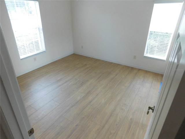 unfurnished room with light wood-type flooring and plenty of natural light