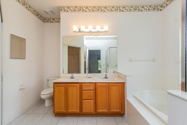 bathroom featuring tile patterned flooring, a relaxing tiled tub, toilet, and vanity