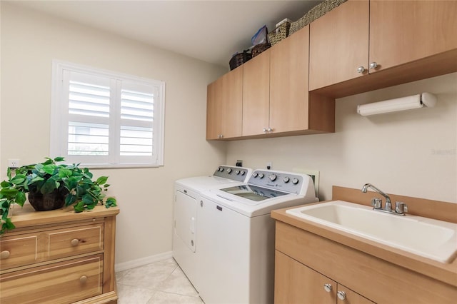 laundry room with light tile floors, cabinets, sink, and washing machine and clothes dryer