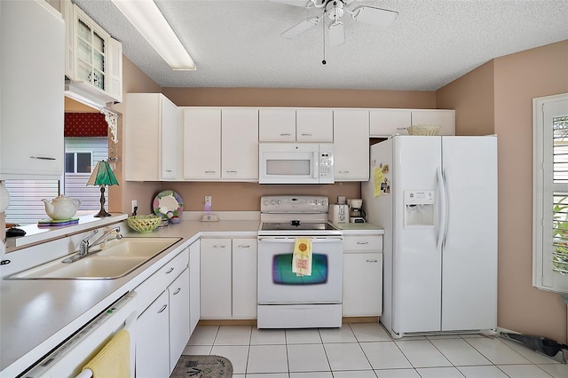 kitchen featuring ceiling fan, white appliances, sink, light tile floors, and white cabinets