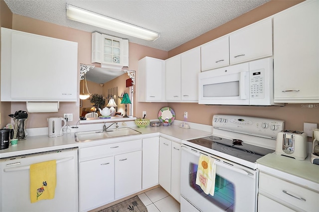 kitchen featuring white appliances, white cabinets, and sink