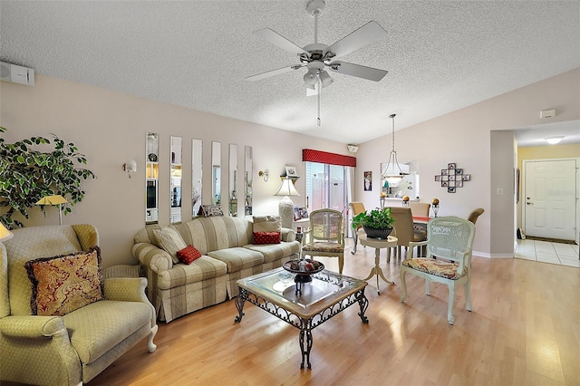 tiled living room featuring vaulted ceiling, a textured ceiling, and ceiling fan