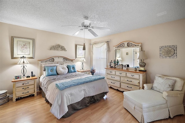 bedroom featuring a textured ceiling, ceiling fan, and light wood-type flooring