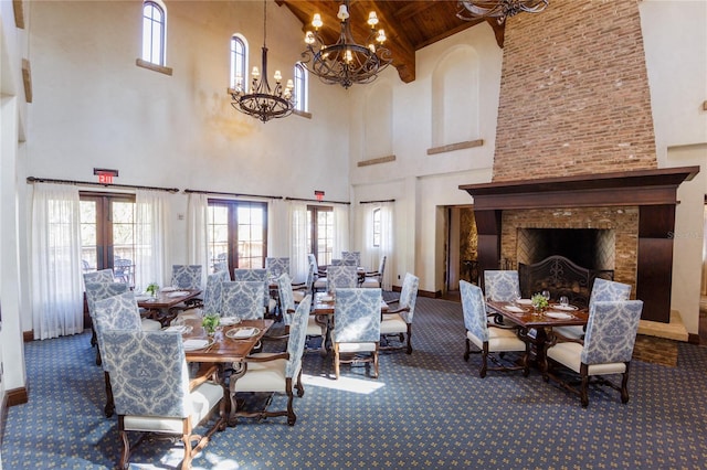 carpeted dining space with baseboards, a fireplace, wood ceiling, and a notable chandelier