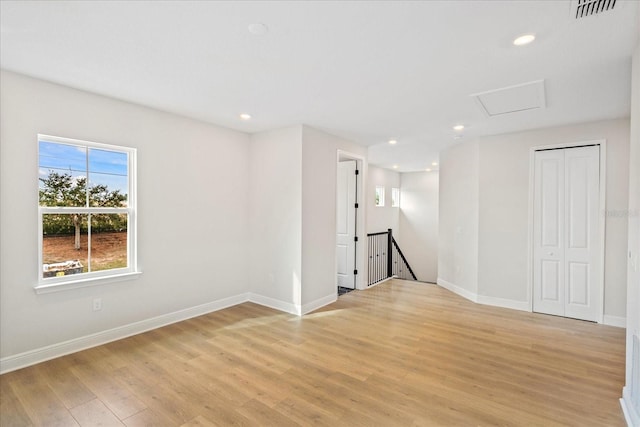 spare room featuring recessed lighting, visible vents, baseboards, light wood-style floors, and attic access