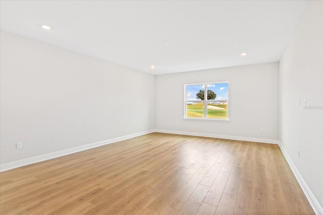 empty room with recessed lighting, light wood-style flooring, and baseboards