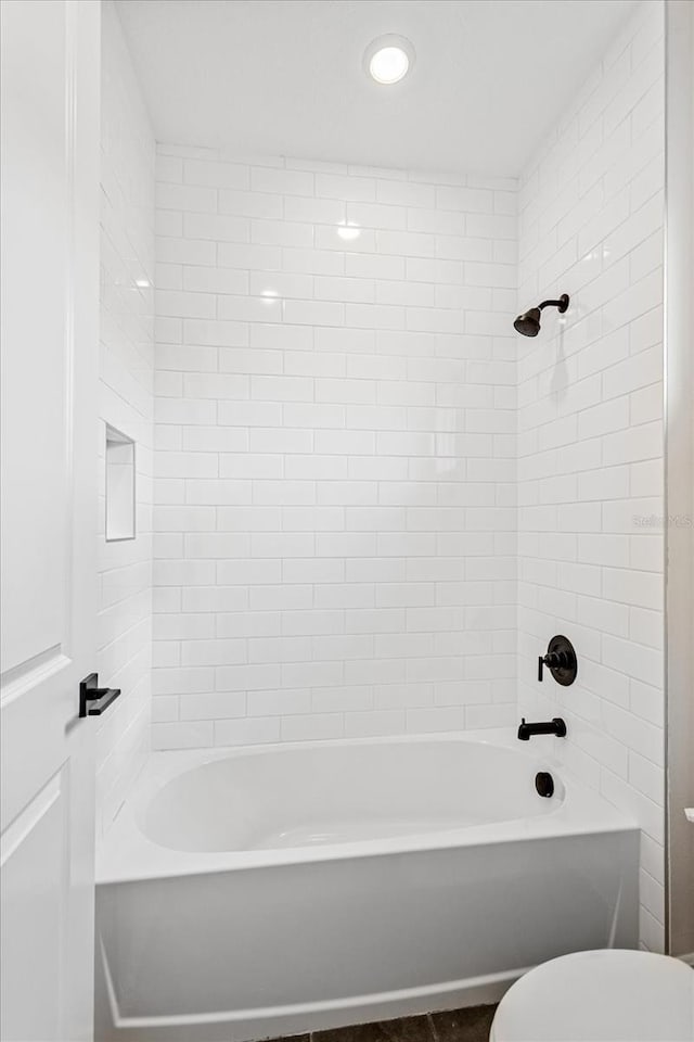 bathroom with toilet and bathing tub / shower combination