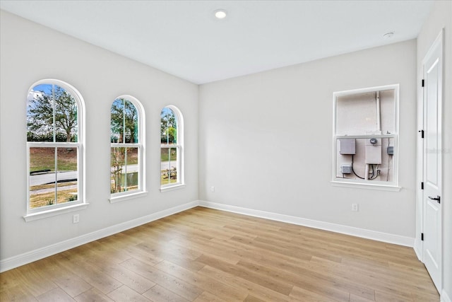 unfurnished room featuring light wood finished floors and baseboards