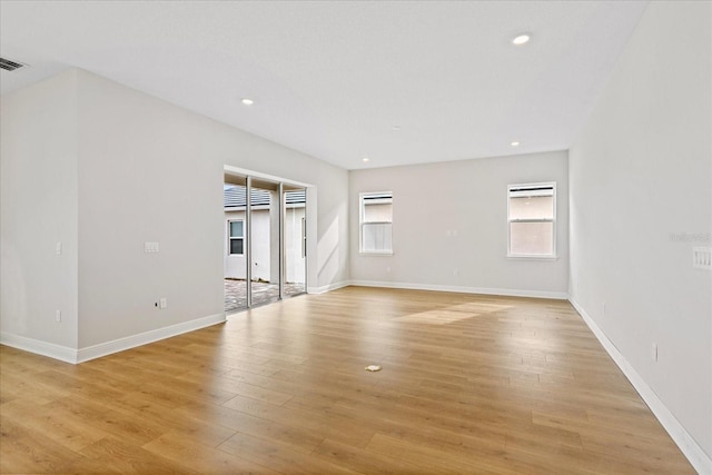 unfurnished living room with light wood-type flooring, baseboards, and recessed lighting