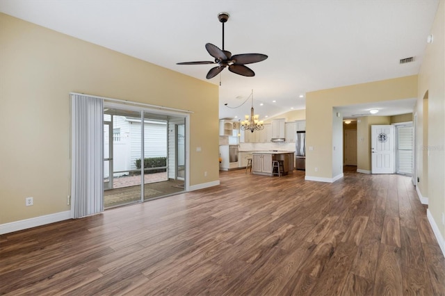 unfurnished living room with ceiling fan with notable chandelier, wood-type flooring, and lofted ceiling