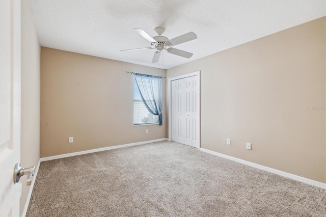 spare room featuring a textured ceiling, carpet floors, and ceiling fan