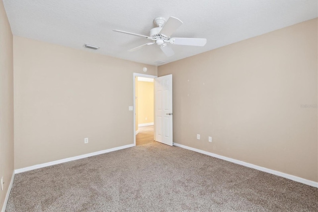 carpeted spare room featuring ceiling fan