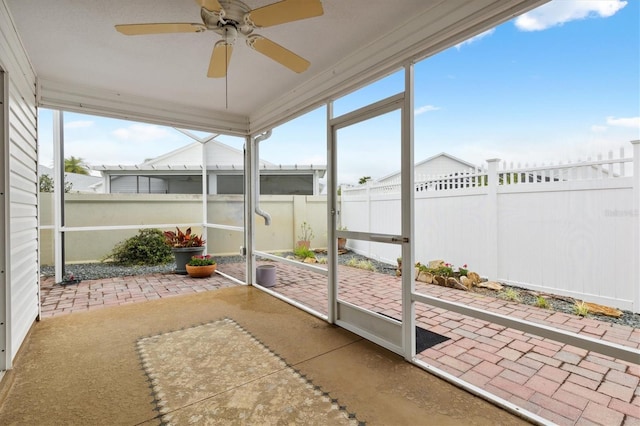 unfurnished sunroom with ceiling fan