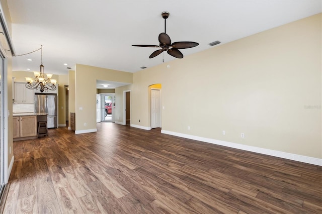 unfurnished living room with ceiling fan with notable chandelier and dark hardwood / wood-style floors