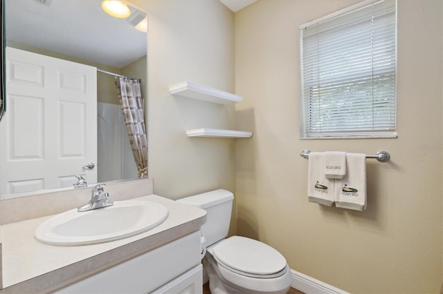 bathroom with toilet, vanity, and a shower with curtain