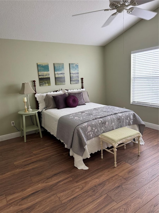 bedroom featuring ceiling fan, vaulted ceiling, a textured ceiling, and dark hardwood / wood-style floors