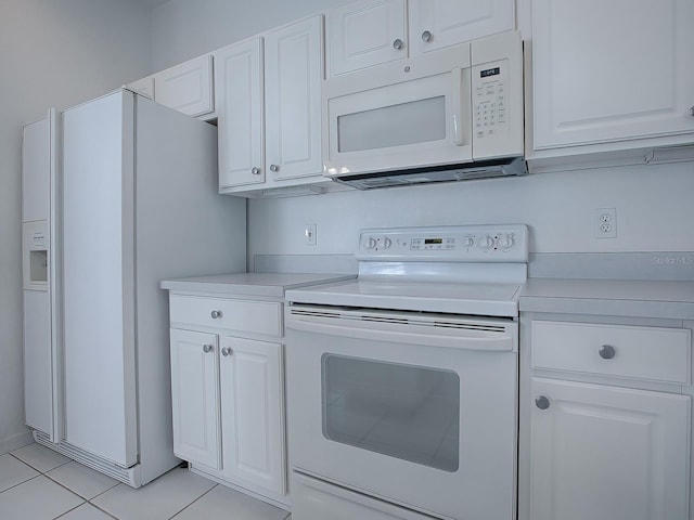 kitchen featuring light tile floors, white appliances, and white cabinetry