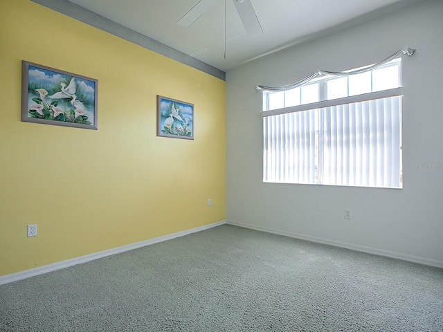 carpeted empty room with ceiling fan and a wealth of natural light