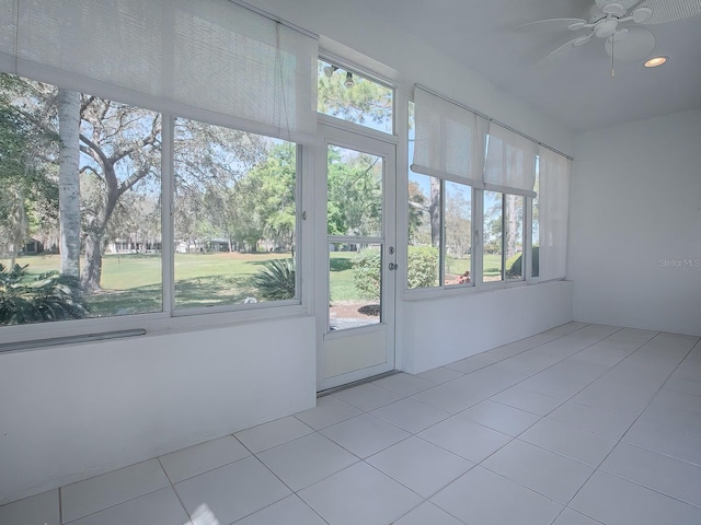 unfurnished sunroom with a healthy amount of sunlight and ceiling fan