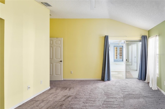 spare room featuring a textured ceiling, ceiling fan, light carpet, and vaulted ceiling