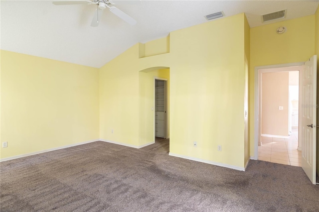 empty room with light carpet, ceiling fan, and vaulted ceiling