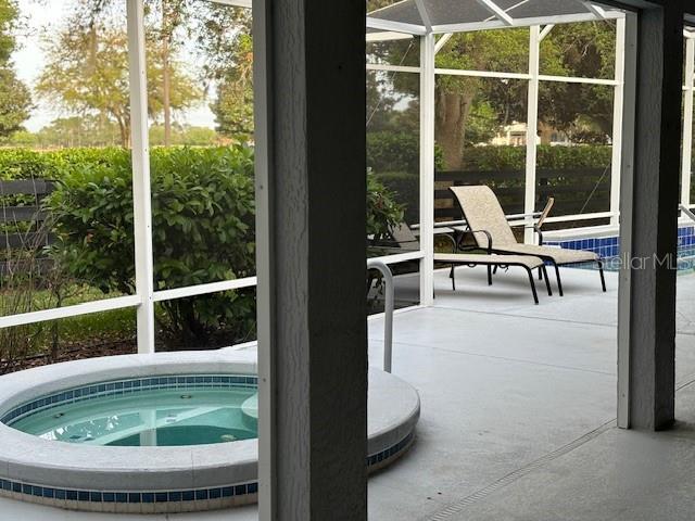 view of pool with a lanai, an in ground hot tub, and a patio