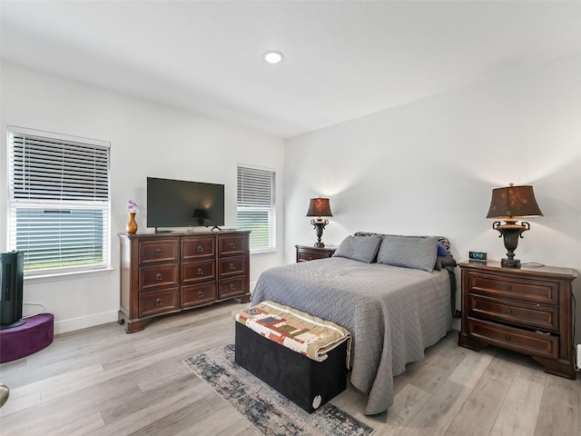 bedroom with multiple windows and light wood-type flooring