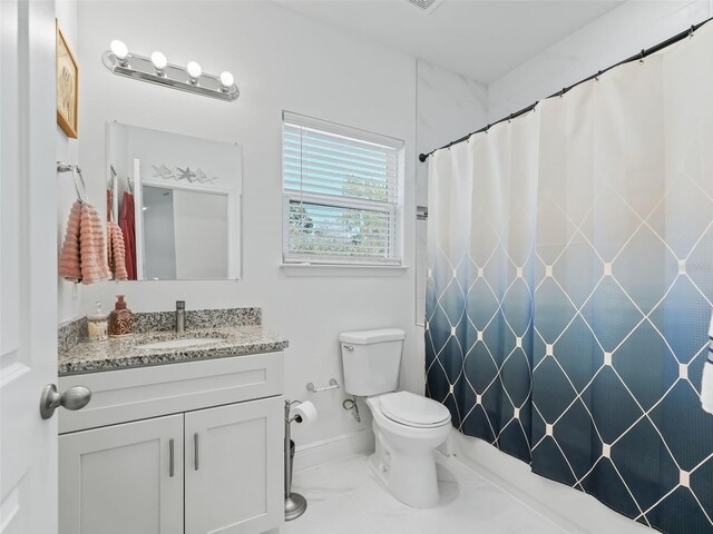 bathroom with tile floors, toilet, and vanity