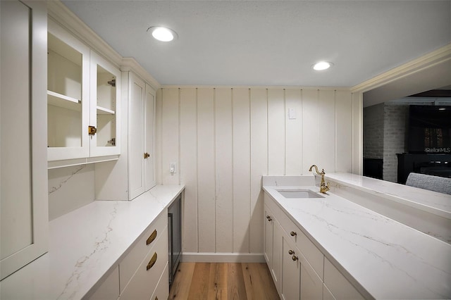 bathroom featuring hardwood / wood-style flooring, brick wall, and vanity