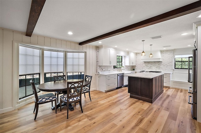 dining area featuring beam ceiling and light hardwood / wood-style floors