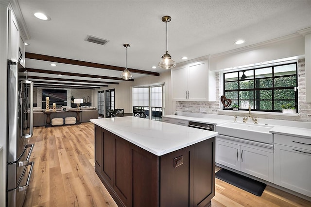 kitchen with light hardwood / wood-style flooring, hanging light fixtures, white cabinets, and appliances with stainless steel finishes