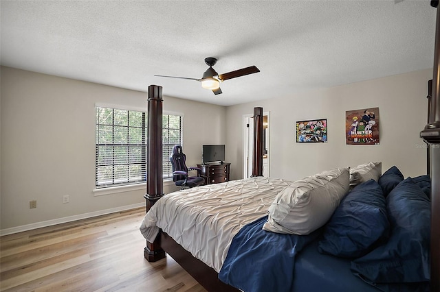 bedroom featuring ceiling fan, a textured ceiling, and light wood-type flooring