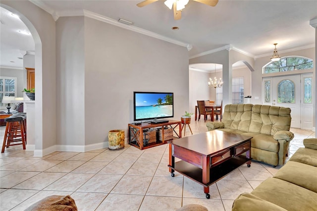 living room with ceiling fan with notable chandelier, light tile patterned floors, and crown molding