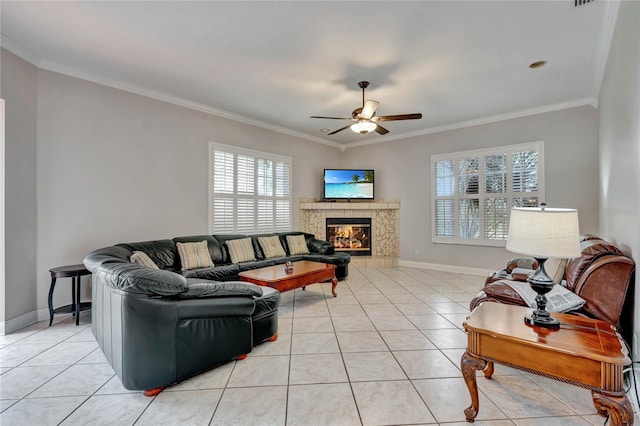 living room featuring ceiling fan, crown molding, a high end fireplace, and a wealth of natural light