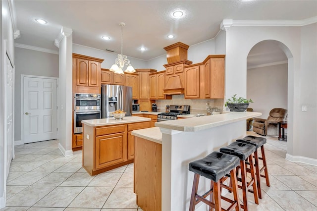 kitchen featuring tasteful backsplash, kitchen peninsula, light tile patterned floors, stainless steel appliances, and a kitchen bar