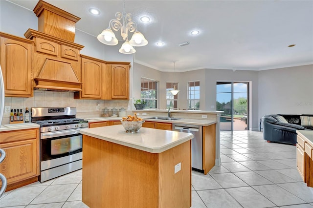 kitchen featuring pendant lighting, a center island, an inviting chandelier, appliances with stainless steel finishes, and a healthy amount of sunlight