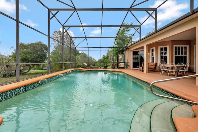 view of swimming pool with pool water feature, glass enclosure, and a patio area