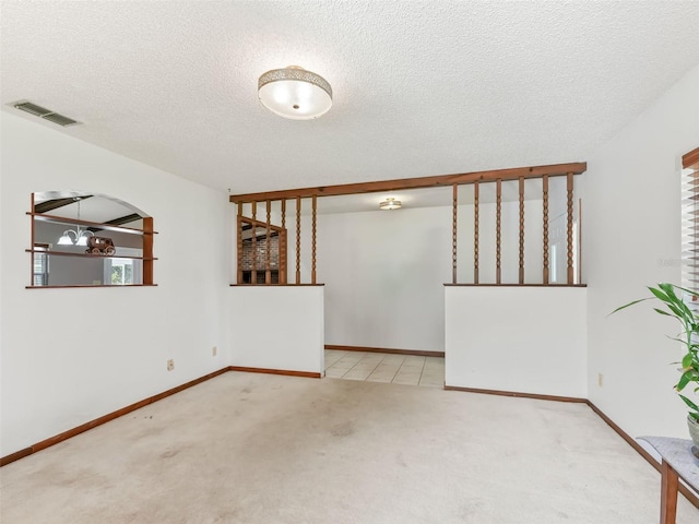 carpeted spare room with a textured ceiling