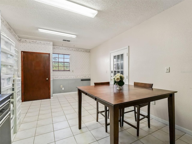 tiled dining space with a textured ceiling