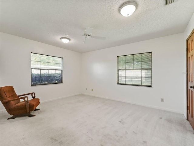 unfurnished room with light carpet, a textured ceiling, and ceiling fan